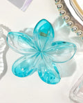 Blue flower-shaped hairclip on a white background